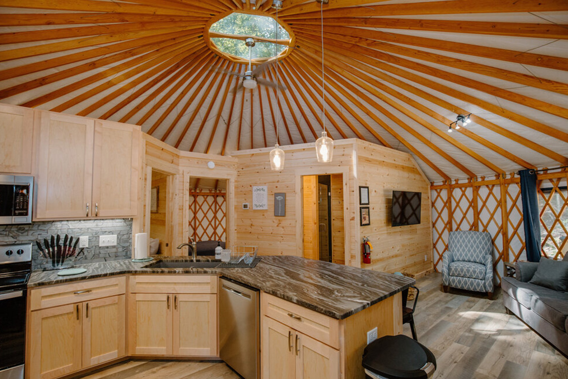 Kitchen space of a Pacific Yurt with light wooden walls.