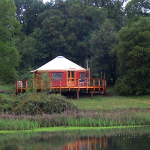 McCormic 30' Pacific Yurt with a raised porch next to a river.