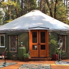 Pacific Yurt with green tarp and grey roof cover.