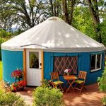 Pacific Yurt with a blue canvas and a wooden deck.