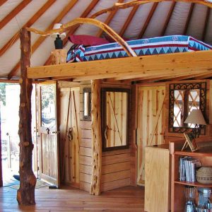 Loft area with a bed inside of a Pacific Yurt.
