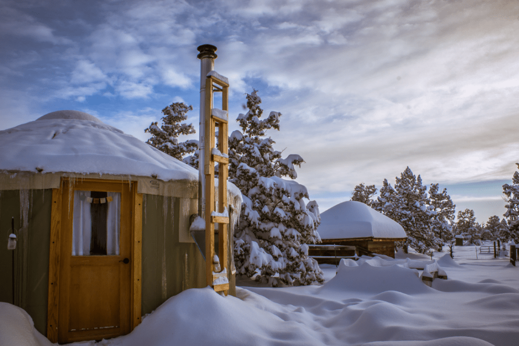 yurt in snow covered field.