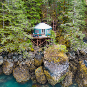 A Pacific Yurt with a teal yurt canvas on the edge of Orca Island.