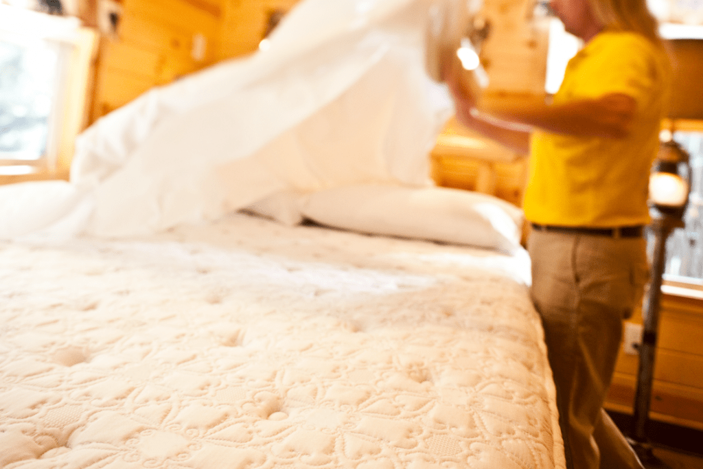 preparing a mattress inside of a pacific yurt.