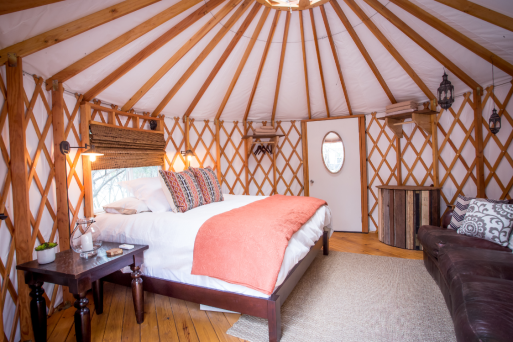 Queen sized bed inside a small Pacific yurt.